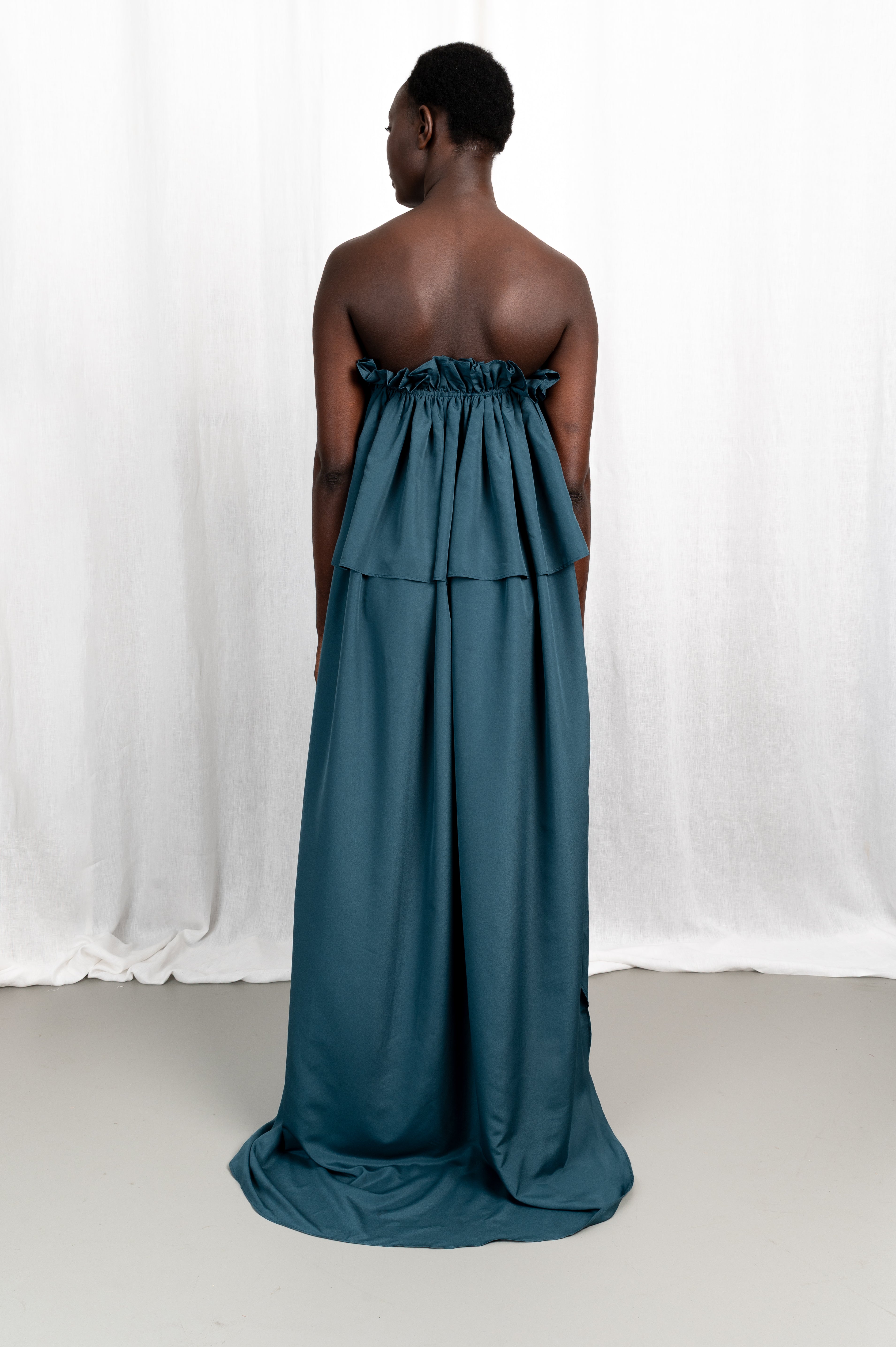 Modèle portant la robe Tamït en crêpe de Chine satiné, vue de dos #couleur_bleu vert profond