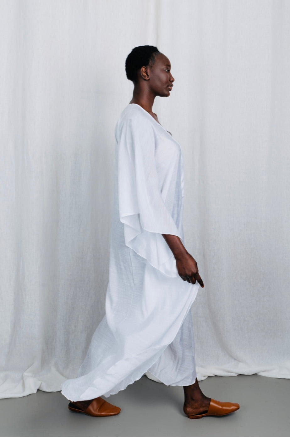 Modèle portant la robe Maali en voile de coton blanc, vue en mouvement