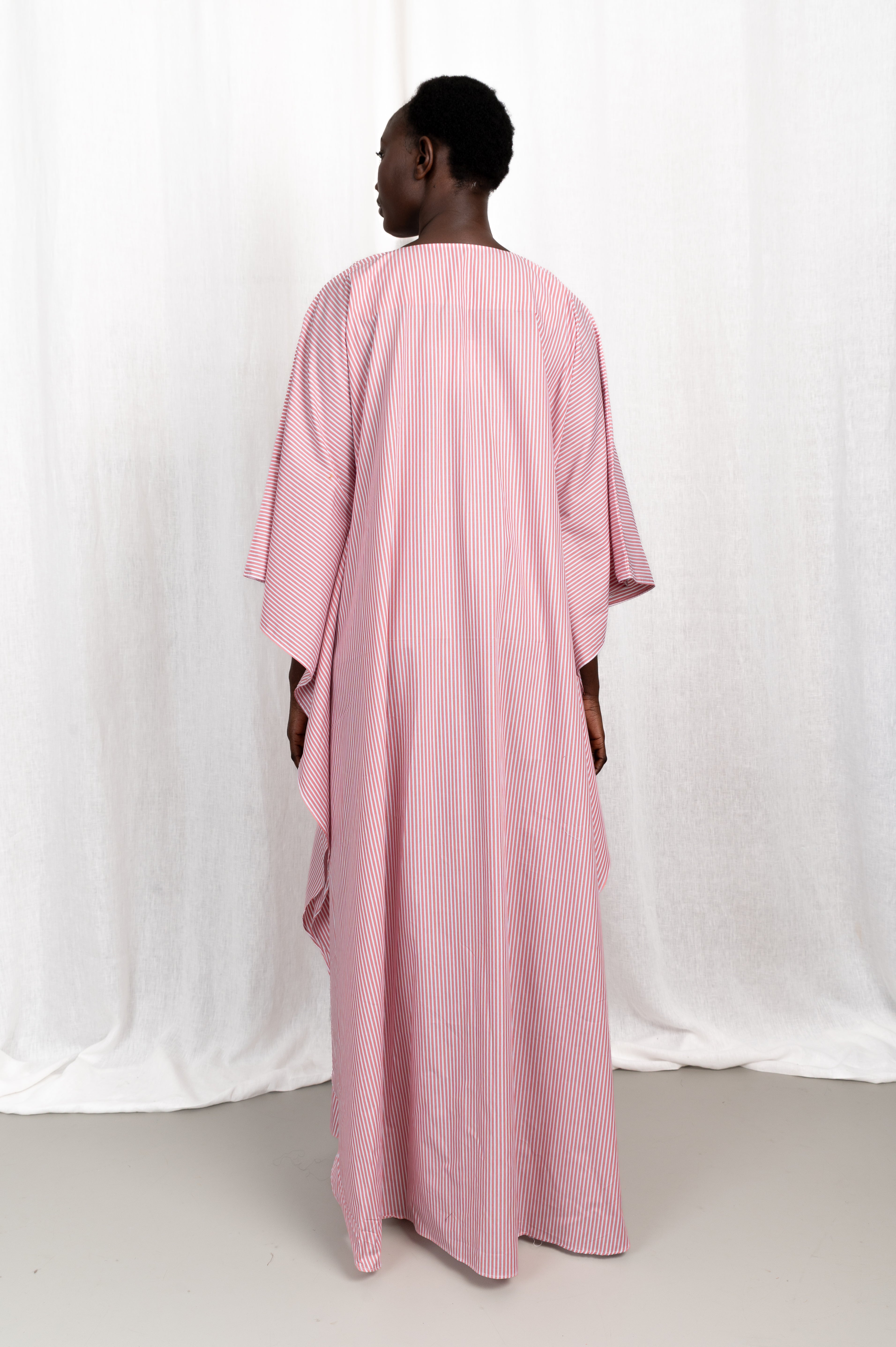 Modèle portant la robe Nia rose en coton et rayures roses, vue de dos #couleur_rose